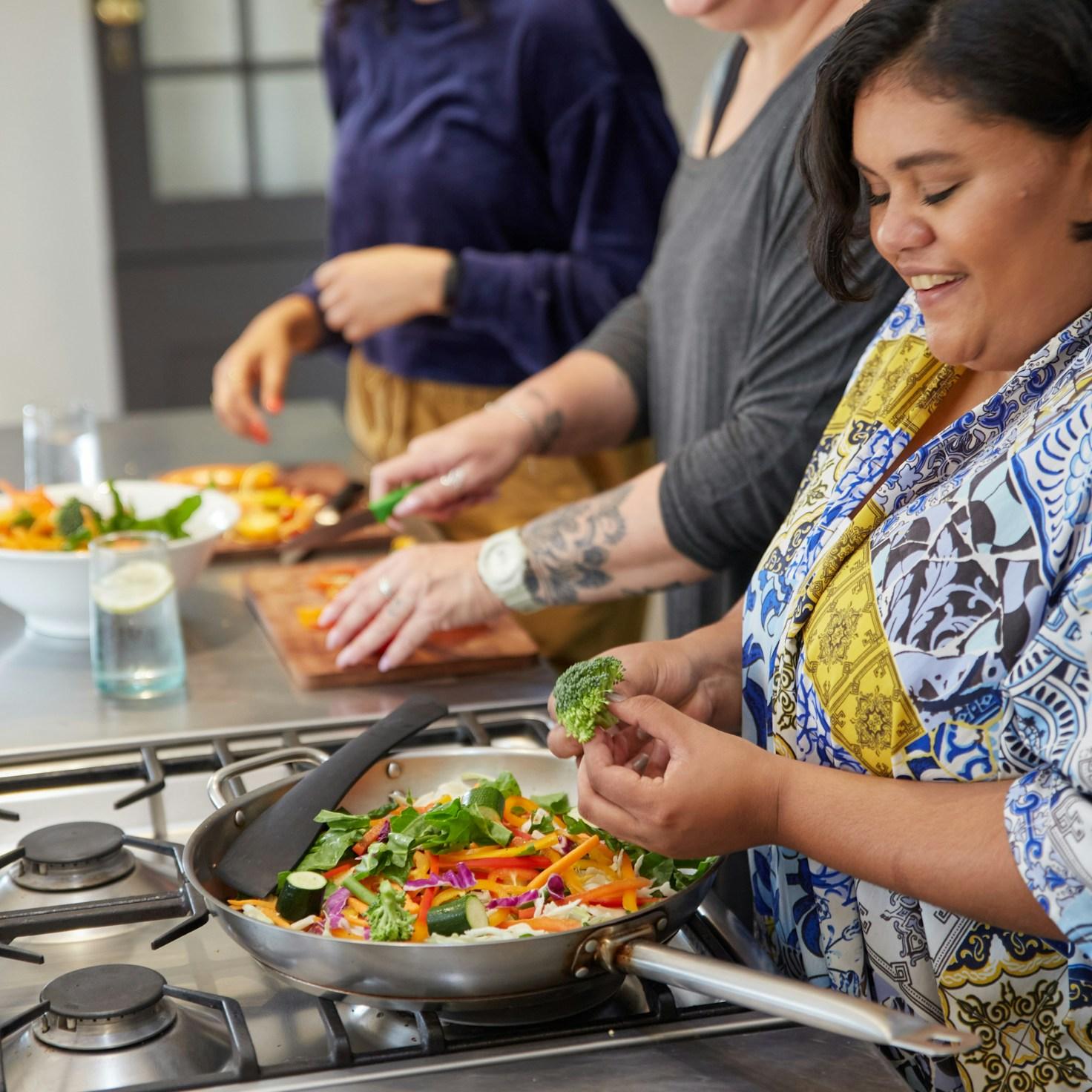 Diverse group of community members sharing a meal, highlighting the bonds built through collaborative cooking